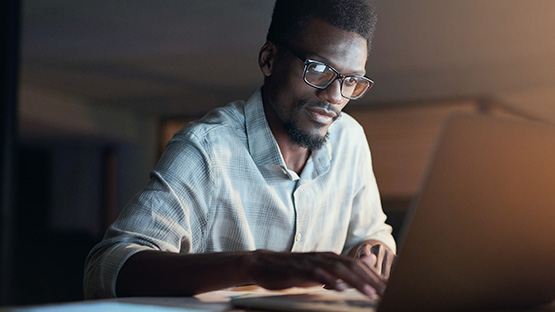 Photo of African-american man using laptop