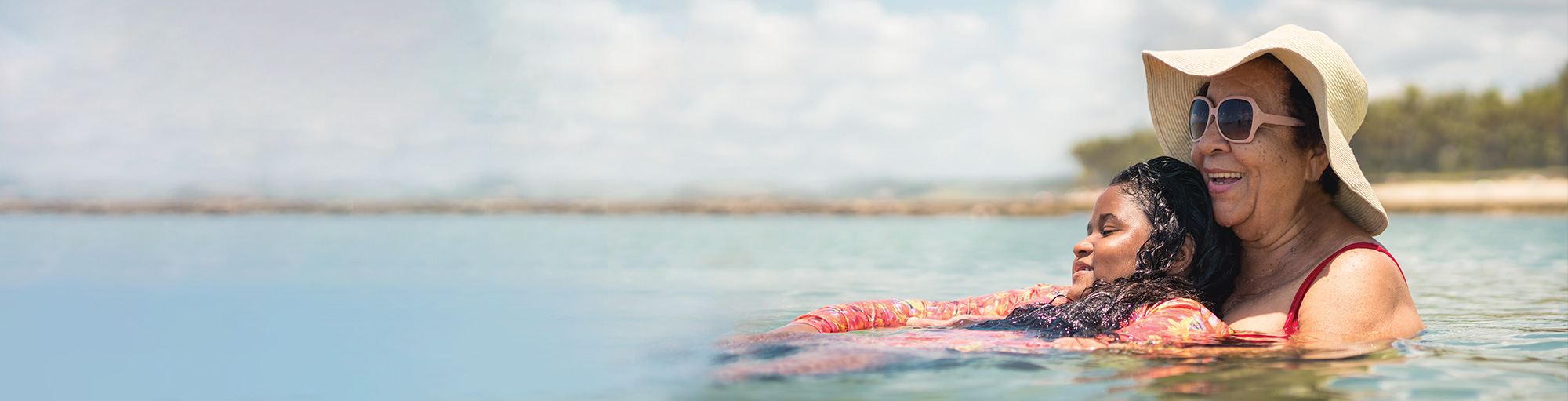 Grandmother and granddaughter swimming in shallow lake water