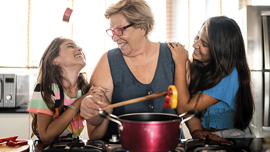Grandmother and granddaughters bonding over cooking in the kitchen