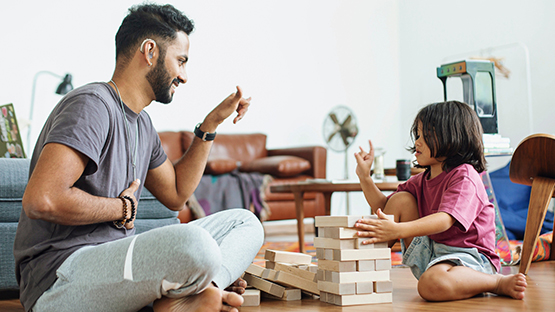 Father and child playing with blocks and communicating using American Sign Language