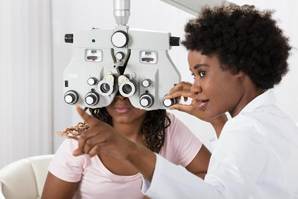 A patient and eye doctor chat during an eye exam